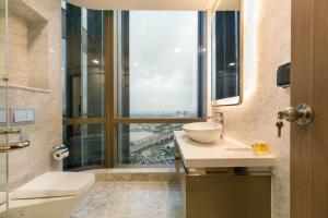 a bathroom with a sink and a large window at Moxy HCMC Aparts - Vinhomes Central Park, Ice Rink in Ho Chi Minh City