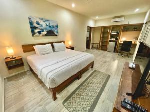 a bedroom with a bed and a television in it at Aldea Xaan Ha Tulum in Tulum +118 photos