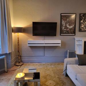 uma sala de estar com uma televisão de ecrã plano na parede em 5 Luxury Spacious Loft - Prime Location - Comfortable Bed & Sofa em Brighton & Hove