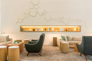 a lobby with chairs and a couch and a mirror at Le Royal Meridien Beach Resort & Spa Dubai in Dubai