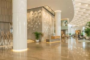 a lobby of a building with potted plants at Le Royal Meridien Beach Resort & Spa Dubai in Dubai