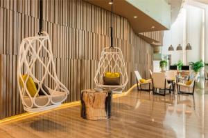 a lobby with white chairs and a table at Le Royal Meridien Beach Resort & Spa Dubai in Dubai
