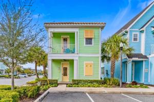 a green house with yellow doors and palm trees at 3000 Latitude Lane in Orlando
