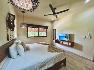 a bedroom with a bed and a ceiling fan at Aldea Xaan Ha Tulum in Tulum