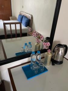a tray with water bottles and glasses on a table at Win Mansion in Bangkok