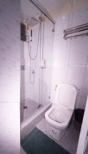 a white bathroom with a shower and a toilet at 1775 Adriatico Suites in Manila