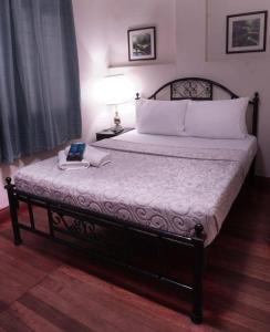um quarto com uma cama grande e um candeeiro. em 1775 Adriatico Suites em Manilla