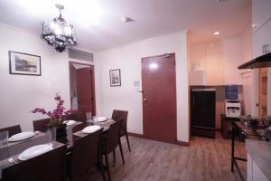 a dining room with a table and chairs and a red door at 1775 Adriatico Suites in Manila