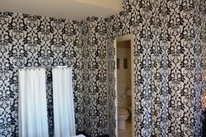 a bathroom with a black and white patterned wall at Hotel Universo - WTB Hotels in Florence