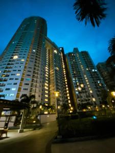 a tall building at night with lights at Fully furnished condo in Quezon City in Manila