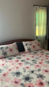 a bedroom with a bed with flowers on it at Baan Bettina Haus 1 in Ban Chak Phai