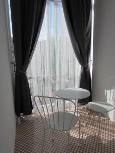 una mesa y dos sillas frente a una ventana en Pensió Cerdanya, en Barcelona