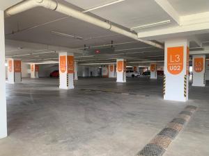 an empty parking garage with orange and white columns at David Studio Unicity, Seremban 3 in Seremban