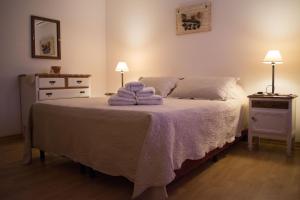 sypialnia z łóżkiem z fioletowymi ręcznikami w obiekcie Hostal Virgen del Rosario Cafayate w mieście Cafayate