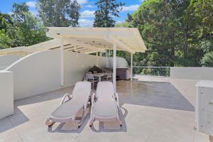 un patio con tavolo e sedie sotto un padiglione di The Cove Noosa - Apartment 19 a Noosa Heads