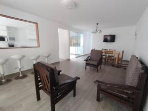 a living room with chairs and a table and a mirror at J&B Aparment 1 Punta Hermosa in Punta Hermosa