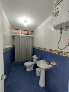 a blue tiled bathroom with a toilet and a sink at J&B Aparment 1 Punta Hermosa in Punta Hermosa