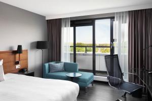 Pokój hotelowy z łóżkiem, krzesłem i oknem w obiekcie Courtyard by Marriott Amsterdam Airport w mieście Hoofddorp