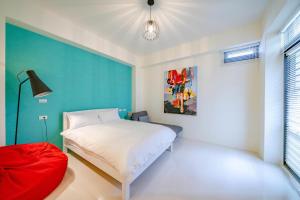 1 dormitorio con cama blanca y pared azul en 放慢1館 放慢民宿 6-14人,只接一組客人,按人數開放房間 en Hualien