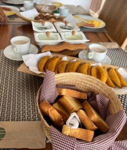 a table with a basket of bread and plates of food at HOTEL PLAZA BOLIVAR MOMPOX ubicado en el centro histórico con parqueadero interno in Mompos