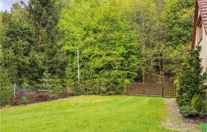 a yard with a wooden fence and green grass at Beautiful Home In Krzynia With Wifi in Krzynia