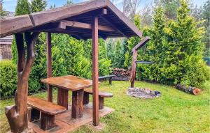 a wooden picnic table and bench in a garden at Beautiful Home In Krzynia With Wifi in Krzynia