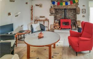 ein Wohnzimmer mit einem Tisch und einem Kamin in der Unterkunft Stunning Home In Plouguerneau With Kitchen in Plouguerneau