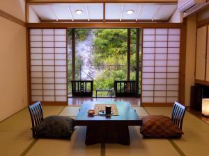 um quarto com uma mesa e cadeiras e uma janela em Fulsato em Tsuchihatakozan