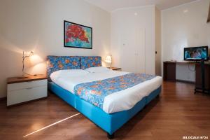 1 dormitorio con 1 cama grande y cabecero azul en Residence Sacchi Aparthotel en Turín