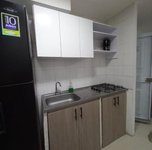 a kitchen with a sink and a stove and cabinets at Apto nuevo, amoblado sector tranquilo, buen precio in Barranquilla