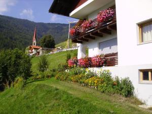 a building with flowers on the side of it at Haus Tasser in San Lorenzo di Sebato