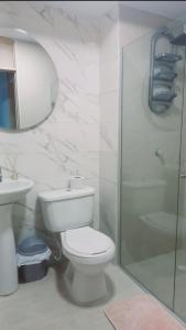 een witte badkamer met een toilet en een douche bij Apto nuevo, amoblado sector tranquilo, buen precio in Barranquilla