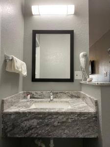 a bathroom with a marble sink and a mirror at Copper Manor Motel in Silver City +63 photos