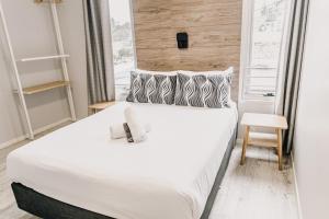 1 dormitorio con 1 cama blanca grande y ventana en Yamba Central, en Yamba