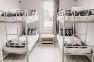 a room with three bunk beds and a window at Yamba Central in Yamba
