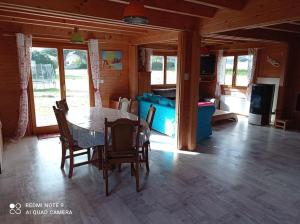 ein Esszimmer mit einem Tisch und Stühlen in einem Haus in der Unterkunft Chalet Familial en Bois à 150 m de la Mer in Santec