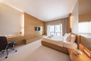 una grande camera d'albergo con letto e scrivania di At 115 Hotel By Rompo a Bangkok