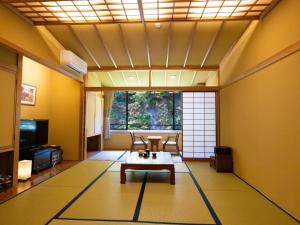 uma sala de estar com uma mesa no meio em Fulsato em Tsuchihatakozan