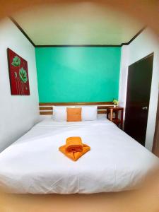Una cama blanca grande con una toalla naranja. en Kalis Viewpoint Lodge Coron, en Corón