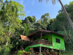 a green house with a balcony in the forest at Chalisa Bukit House Lanta in Ko Lanta