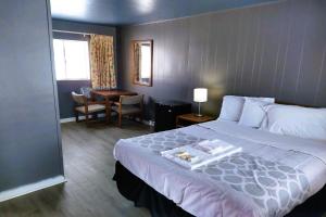 a hotel room with a large bed and a desk at Love Hotels Desert Inn & RV at Boysen Wind River WY 