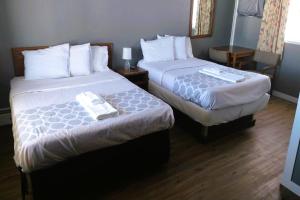 a hotel room with two beds with white sheets at Love Hotels Desert Inn & RV at Boysen Wind River WY 