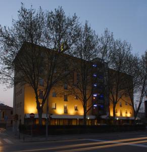 un edificio en una calle con árboles delante en Hotel Fiera Wellness & Spa en Bolonia