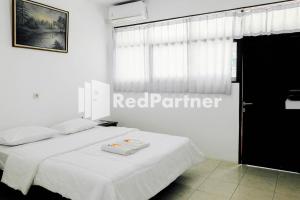 a bedroom with a white bed and a window at Ken Zong Inn Hotel in Cijaringao