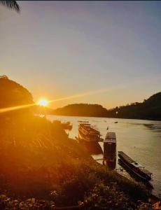 琅勃拉邦的住宿－Villa Alounsavath Mekong Riverside，日落时分坐在水中的一群船