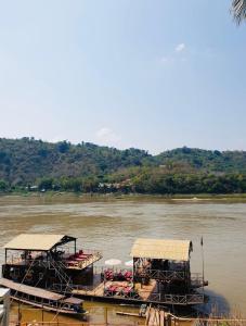 琅勃拉邦的住宿－Villa Alounsavath Mekong Riverside，两艘船停靠在河上