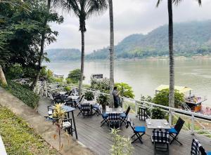 a person standing on a deck overlooking a river at Villa Alounsavath Mekong Riverside in Luang Prabang