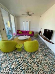 Luxury 1 Bedroom Beach House Casa Dos Aguas في يلابا: غرفة معيشة مع كرسيين أخضر وطاولة