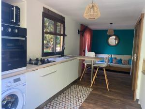a kitchen with a washing machine and a table at Le Palan in Saint-Pierre