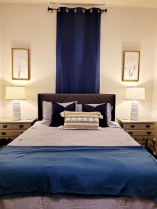 um quarto com uma cama azul e 2 candeeiros em House Clara em Yuba City